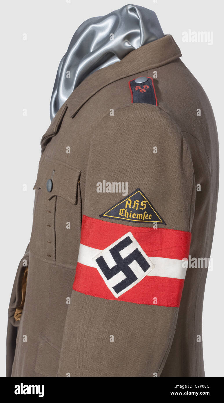 Eine Uniform für einen Schüler des Adolf Hitler Schule Chiemsee,Jacke in speziellem Schnitt mit überdachtem Knopffliege aus braunem Gabardine,feldgrauen Knöpfen und goldenbraunem Seidenfutter. Schwarze Schulterbretter mit roten Paspeln bestickt 'AHS', schwarzer Distriktpatch mit Aufschrift 'AHS Chiemsee' in gelb, gewebtes Armband. Enthalten sind die Hosen aus entsprechendem Material. Kleine Mottenspuren,historisch,historisch,1930er,1930er,20th century,Bund deutscher Mädchen,Band deutscher Mädchen,Jugendorganisation,Jugendorganisationen,NS,Nationalsozialismus,Nationalsozialismus,Drittes Reich,Zusatzrechte-Clearences-nicht verfügbar Stockfoto