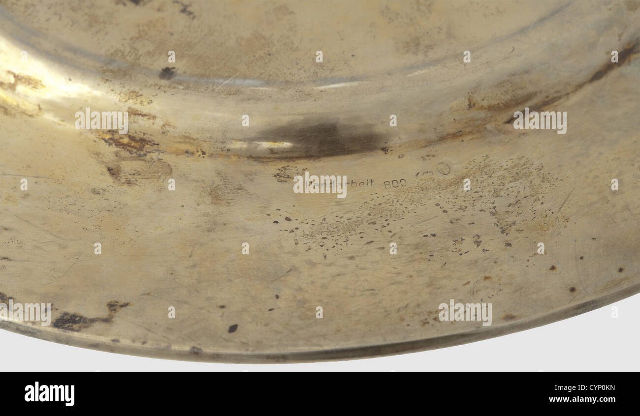 Hermann Göring - eine Vermeilplatte 1939,Silber,vergoldet,die Grenze wurde überwiegend mit Flugzeugtypen der Firma Junkers graviert. In der Mitte ist eine eingravierte Karte der Kontinente Europa, Afrika und Asien, der Länder der Achse geschlüpft: Deutschland, Ostpreußen, Österreich, Italien und Japan. Der Boden markiert 'Handarbeit' und '800' mit Halbmond und Krone. Durchmesser 22.2 cm, Gewicht 329 g. Angehängt ein altes Auktionslabel von Phillips, Auktion 86, Los 490, historisch, historisch, 1930er, 20. Jahrhundert, Luftwaffe, Dienststelle, Dienststellen, bewaffneter Dienst, Zusatzrechte-Clearences-nicht verfügbar Stockfoto