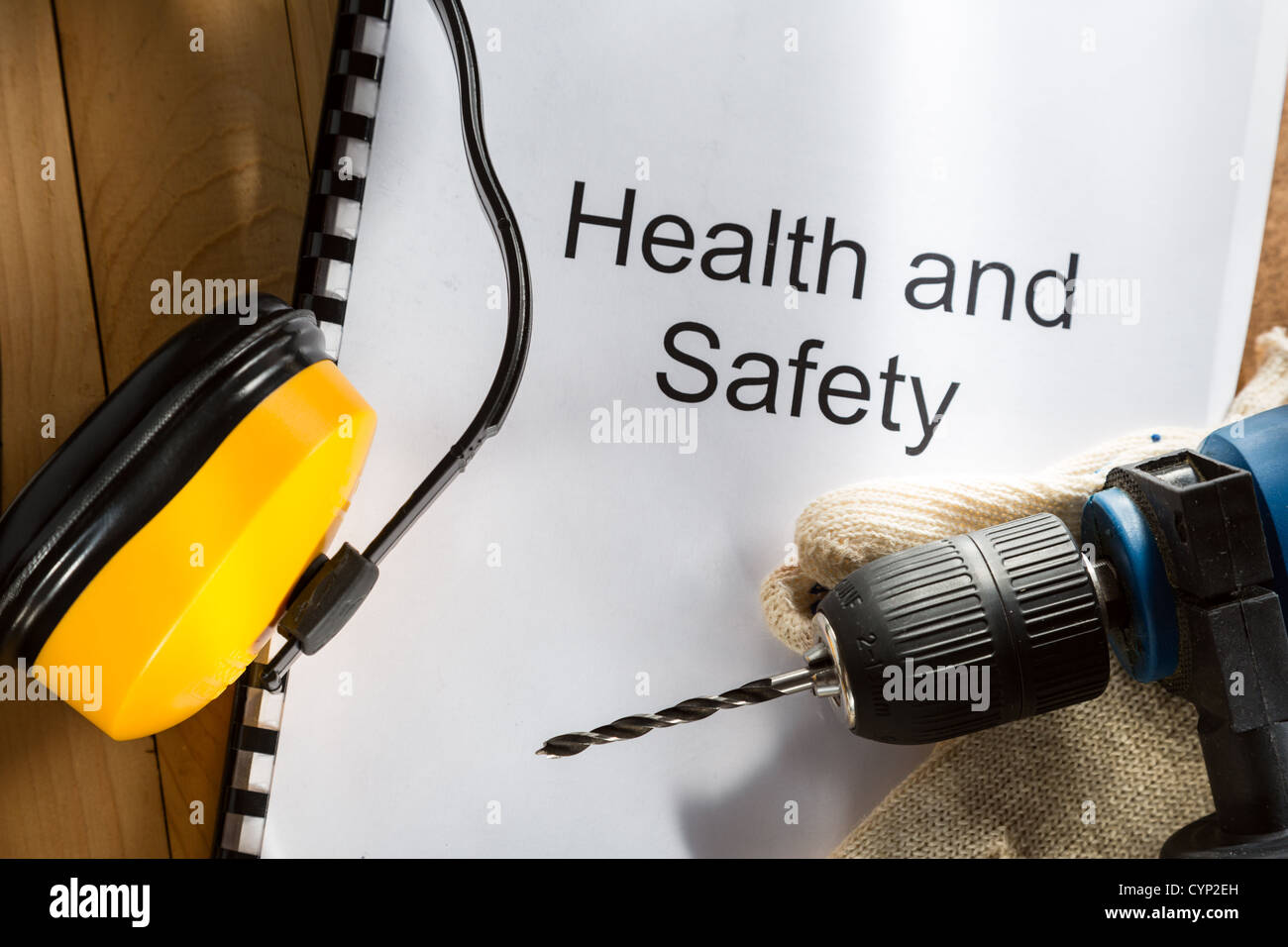 Registrieren Sie mit Bohrer und Handschuhe auf hölzernen Hintergrund Stockfoto