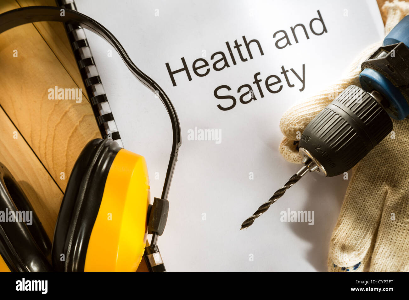 Registrieren Sie mit Bohrer und Handschuhe auf hölzernen Hintergrund Stockfoto