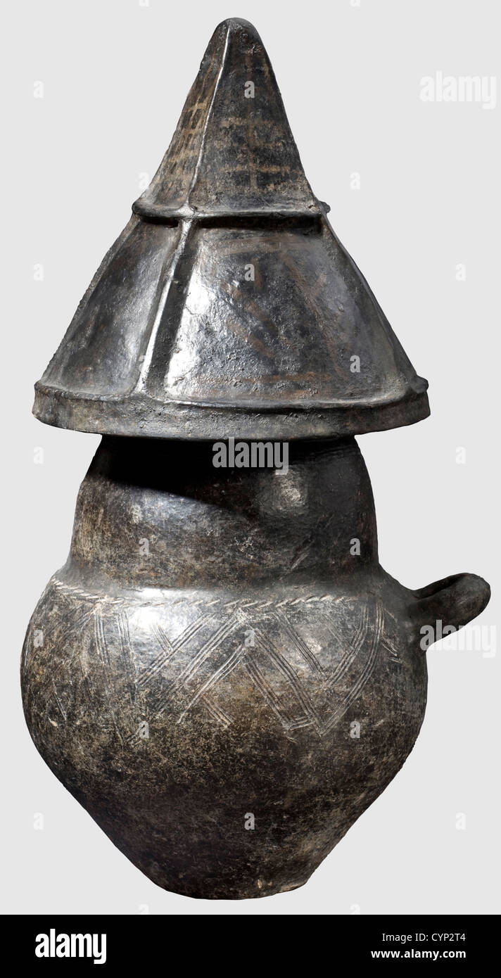 Eine Urne mit spitzen Helmdeckel, Villanova, 9./8. Jahrhundert v. Chr. Dunkelbraun bis schwarz Steingut.Einhandgriff, zweikeilige Urne mit einem Abfackeln Rand und Graffito Dekoration mit weißer Inkrutierung.der obere Teil der Urne mit einem durchgehenden Band aus Mäander.der Deckel in Form eines spitzen Helm durch vier stabile vertikale Rippen und geschnitten Eine horizontale Rippe.die Abschnitte mit gemalten geometrischen Mustern verziert.die horizontale Rippe durchbohrt.Höhe der Urne 33.5 cm,Höhe des Deckels 24.5 cm.kleinere Restaurationen und Ergänzungen.Axel Guttmann Collection(wit,Additional-Rights-Clearences-not available Stockfoto