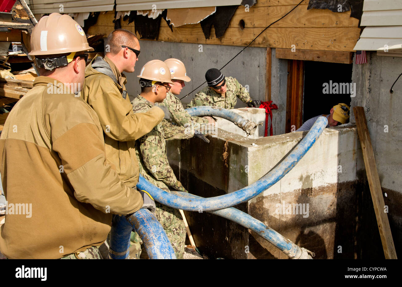 NEW YORK (6. November 2012) Seabees zugewiesen, Bau Bataillon Maintenance Unit (CBMU) 202 und Matrosen zugewiesen, Mobile Tauchen und Salvage Unit (MDSU) 2 arbeiten mit wohnhaft in seinem Keller entwässern, die vom Hurricane Sandy während Relief e überflutet wurde Stockfoto