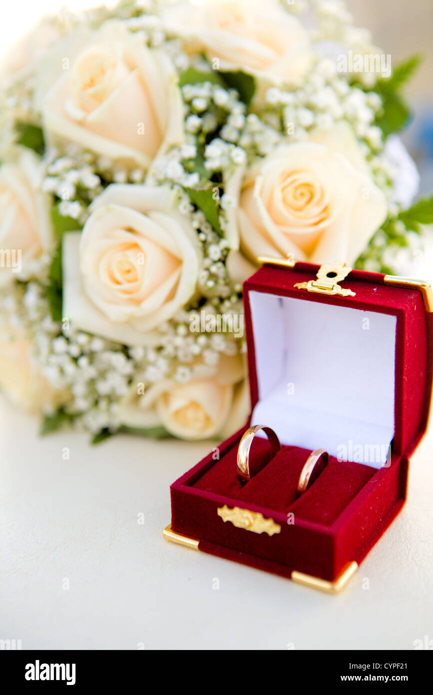 Trauringe in roten Feld in der Nähe von Strauß auf Tisch Stockfoto