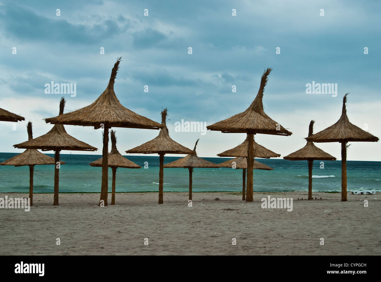 Sonnenschirme an einem einsamen Strand, in den frühen Morgenstunden, bei Sonnenuntergang Stockfoto