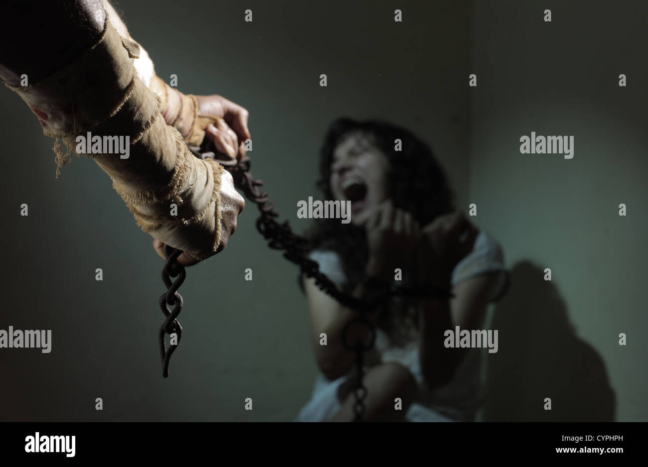 Verkettete Sklavin Frau, gefangen von einem bösen Mann Stockfoto