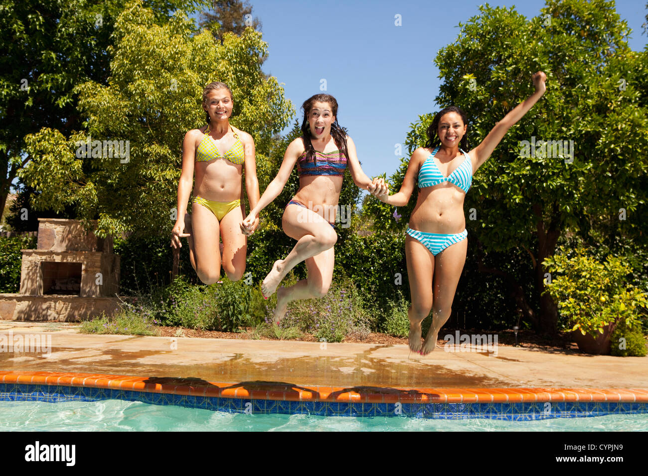 Mädchen zusammen ins Schwimmbad springen Stockfoto