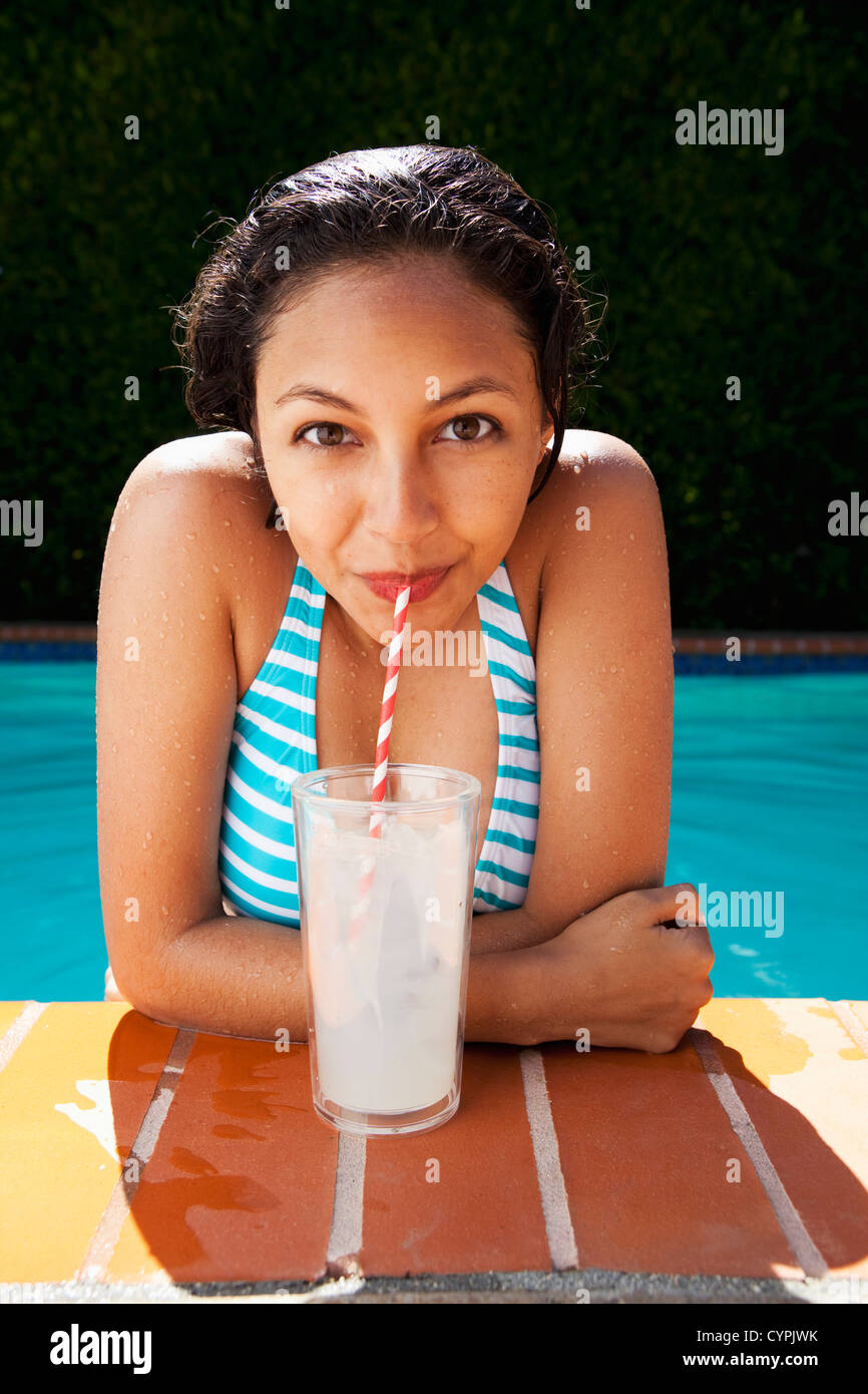 Gemischte Rassen Mädchen trinken Limonade in der Nähe von Schwimmbad Stockfoto