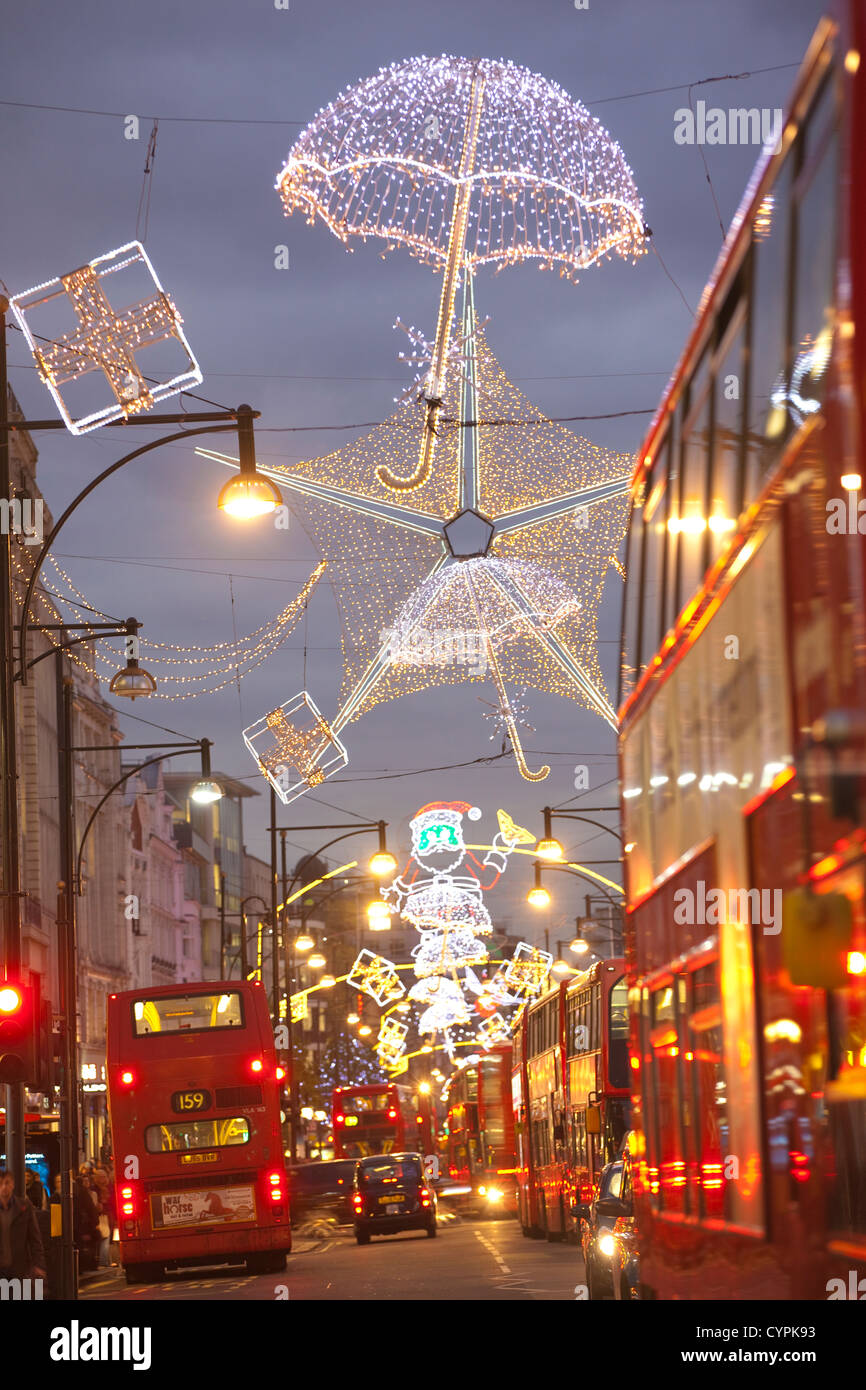 Weihnachtsbeleuchtung während der Hauptverkehrszeit in der Abenddämmerung auf der geschäftigen Oxford Street, Oxford Circus, West End, London, England, Vereinigtes Königreich Stockfoto