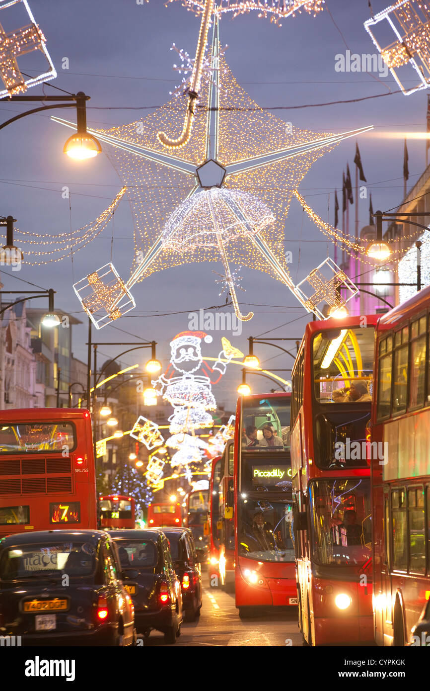 Weihnachtsbeleuchtung während der Hauptverkehrszeit in der Abenddämmerung auf der geschäftigen Oxford Street, Oxford Circus, West End, London, England, Vereinigtes Königreich Stockfoto