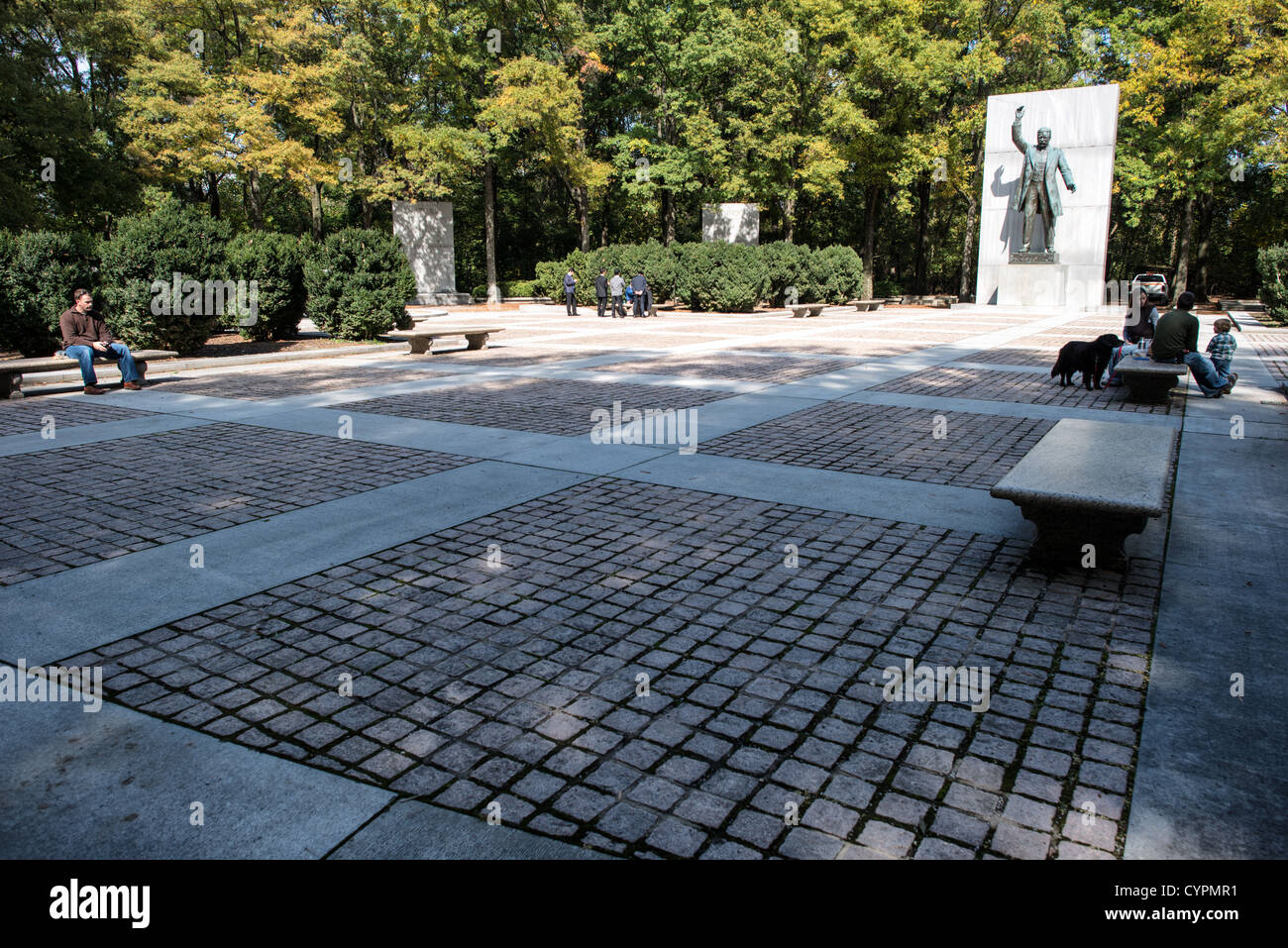WASHINGTON DC – die gepflasterte plaza im Theodore Roosevelt Memorial auf Roosevelt Island dient als formeller Zugang zur Statue des Monuments. Dieser offene Versammlungsraum führt die Besucher zu der 17 Fuß hohen Bronzestatue von Roosevelt mit ausgestreckten Armen, die vom Bildhauer Paul Manship entworfen wurde. Der platz wird von Granitmonolithen flankiert, auf denen Roosevelts bemerkenswerte Zitate über Natur, Naturschutz und bürgerliche Werte geschrieben sind. Als Teil des größeren, 1967 eingeweihten Gedenkkomplexes bietet die plaza einen besinnlichen Raum innerhalb des 88 Hektar großen Inselreservats im Potomac River, der Roos reflektiert Stockfoto