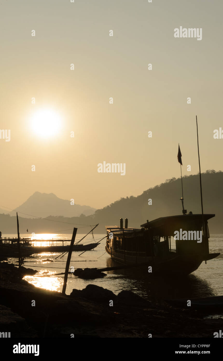 LUANG PRABANG, Laos - der ruhige Fluss Mekong fließt durch das Herz der zum UNESCO-Weltkulturerbe gehörenden Stadt Luang Prabang und bietet eine malerische Kulisse für die antiken Tempel und die französische Kolonialarchitektur. Der Fluss spielt eine wichtige Rolle im täglichen Leben und in der Wirtschaft der Region, da er Landwirtschaft, Fischerei und Transport unterstützt. Stockfoto