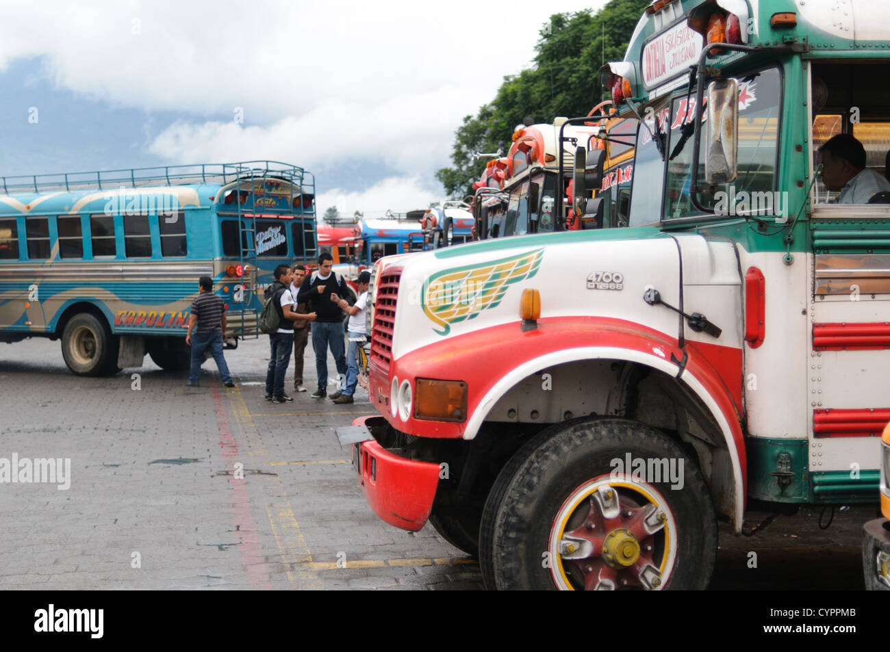 Huhn Busse aufgereiht hinter dem Mercado Municipal (Stadtmarkt) in Antigua, Guatemala. Aus diesem umfangreichen zentralen Busbahnhof strahlenförmig der Routen in Guatemala. Oft bunt bemalt, die Huhn-Busse sind nachgerüsteten amerikanische Schulbusse und bieten ein günstiges Transportmittel im ganzen Land. Stockfoto