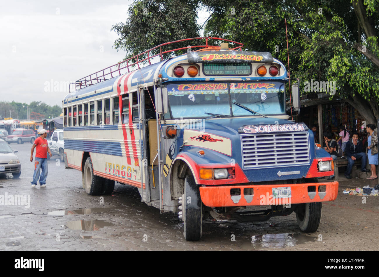 Ein Huhn Bus hinter dem Mercado Municipal (Stadtmarkt) in Antigua, Guatemala. Aus diesem umfangreichen zentralen Busbahnhof strahlenförmig der Routen in Guatemala. Oft bunt bemalt, die Huhn-Busse sind nachgerüsteten amerikanische Schulbusse und bieten ein günstiges Transportmittel im ganzen Land. Stockfoto
