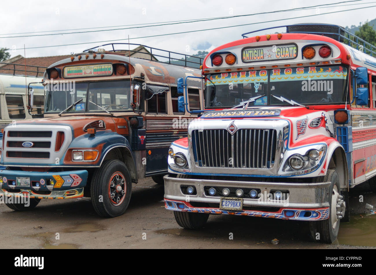 Zwei Chicken Busse hinter dem Mercado Municipal (Stadtmarkt) in Antigua, Guatemala. Aus diesem umfangreichen zentralen Busbahnhof strahlenförmig der Routen in Guatemala. Oft bunt bemalt, die Huhn-Busse sind nachgerüsteten amerikanische Schulbusse und bieten ein günstiges Transportmittel im ganzen Land. Stockfoto