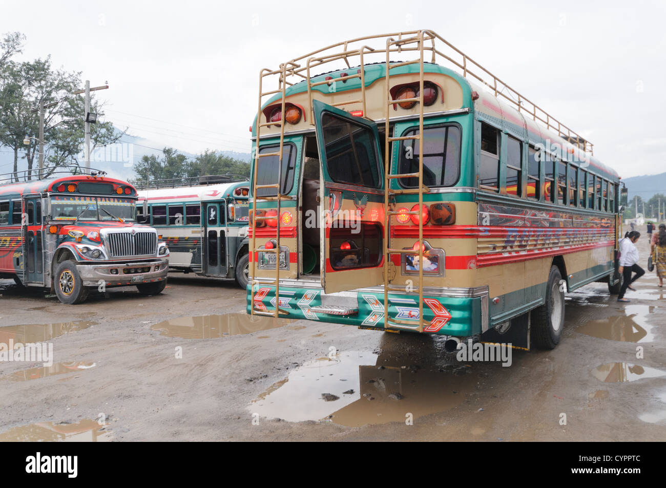 Laden Huhn Busse hinter dem Mercado Municipal (Stadtmarkt) in Antigua, Guatemala. Aus diesem umfangreichen zentralen Busbahnhof strahlenförmig der Routen in Guatemala. Oft bunt bemalt, die Huhn-Busse sind nachgerüsteten amerikanische Schulbusse und bieten ein günstiges Transportmittel im ganzen Land. Stockfoto