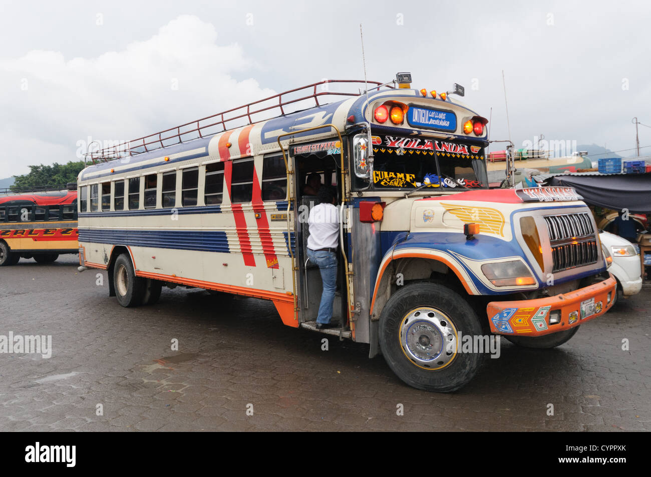 Reiten Sie Huhn Busse hinter dem Mercado Municipal (Stadtmarkt) in Antigua, Guatemala. Aus diesem umfangreichen zentralen Busbahnhof strahlenförmig der Routen in Guatemala. Oft bunt bemalt, die Huhn-Busse sind nachgerüsteten amerikanische Schulbusse und bieten ein günstiges Transportmittel im ganzen Land. Stockfoto