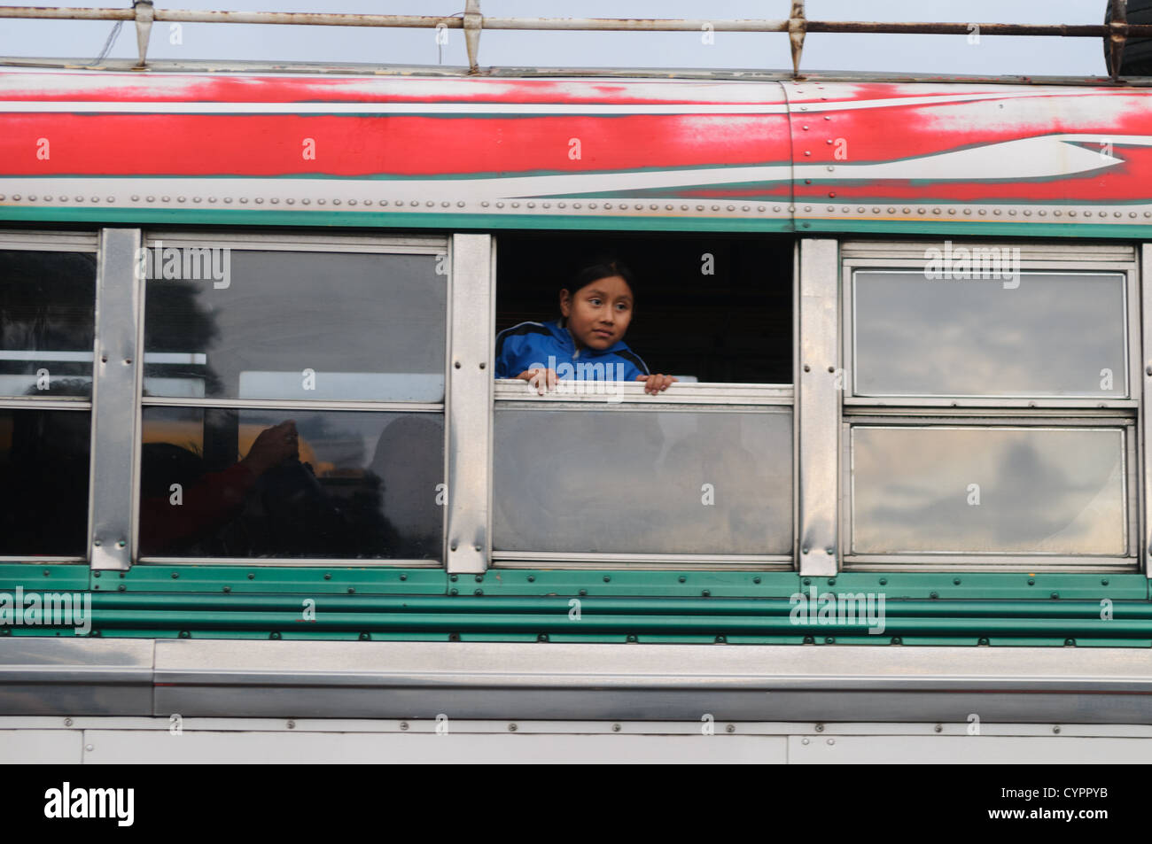 Guatemaltekische Hühnerbusse Kinderpassagier Antigua GUATEMALA // ANTIGUA GUATEMALA, Guatemala — bunt bemalte Hühnerbusse säumen eine Straße in Antigua Guatemala. Diese umgestalteten amerikanischen Schulbusse mit lebendigen Designs und Chromaccessoires sind bereit, Einheimische und abenteuerlustige Touristen zu transportieren und verkörpern Guatemalas lebendige Verkehrskultur vor dem Hintergrund der kolonialen Architektur. Stockfoto