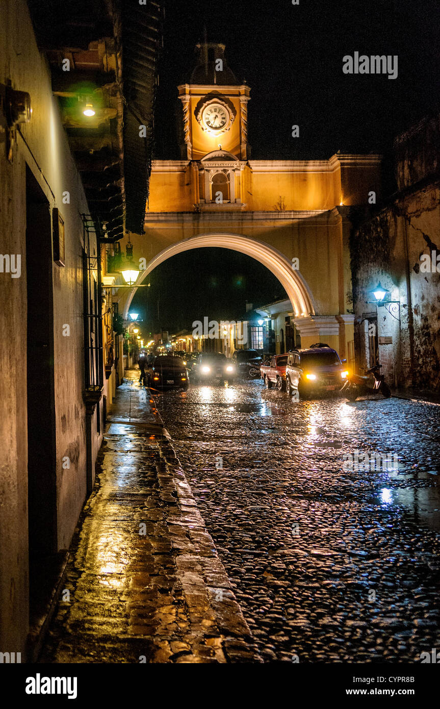 Der Torbogen über die Straße des Klosters Santa Catalina in zentralen Antigua, Guatemala, mit dem Wasser aus den letzten Regen reflektieren das Licht auf der Straße mit Kopfsteinpflaster. Stockfoto