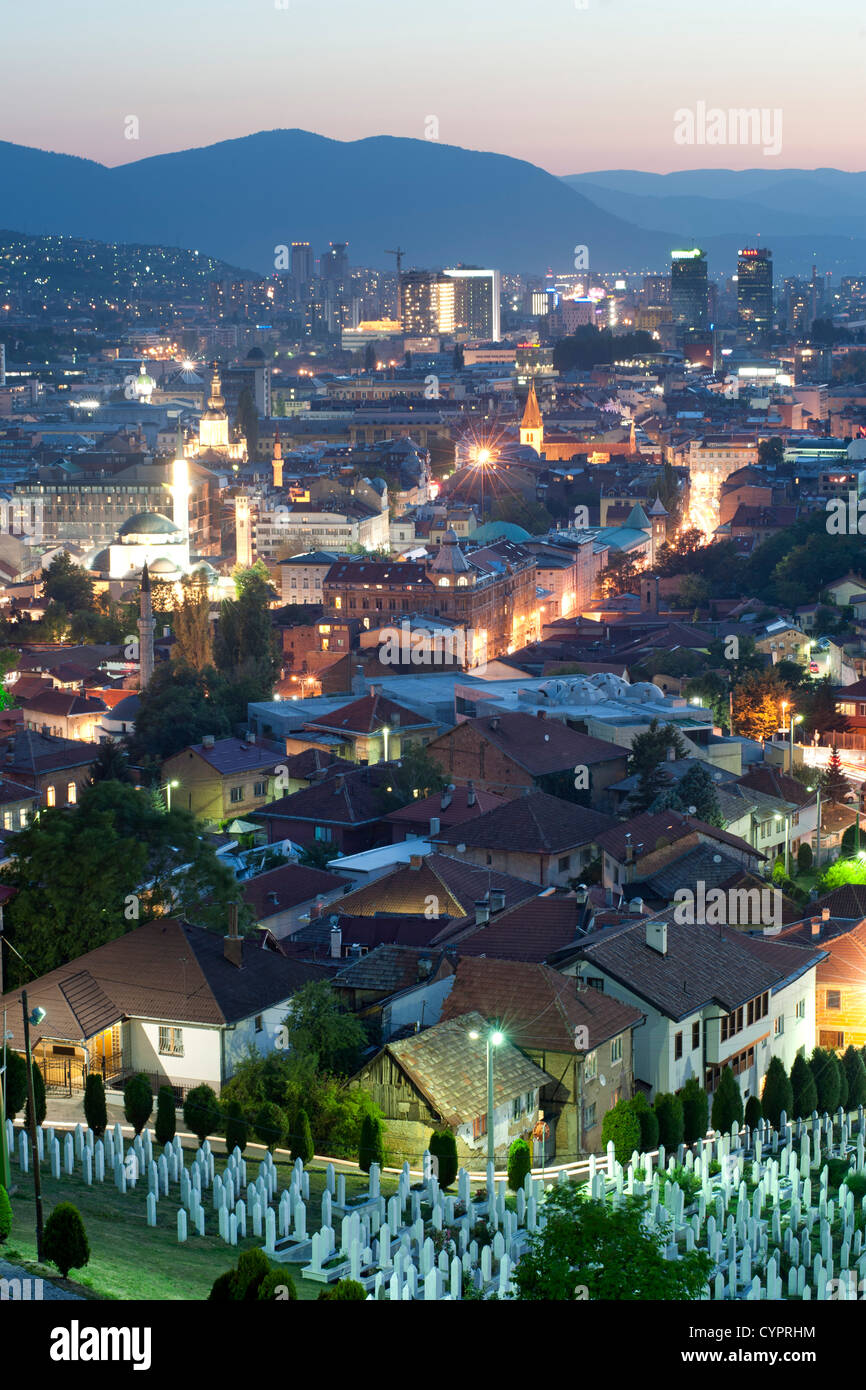Abenddämmerung Ansicht von Sarajevo, das Kapital Stadt von Bosnien und Herzegowina. Im Vordergrund steht die Märtyrer Gedenkfriedhof Kovaci. Stockfoto
