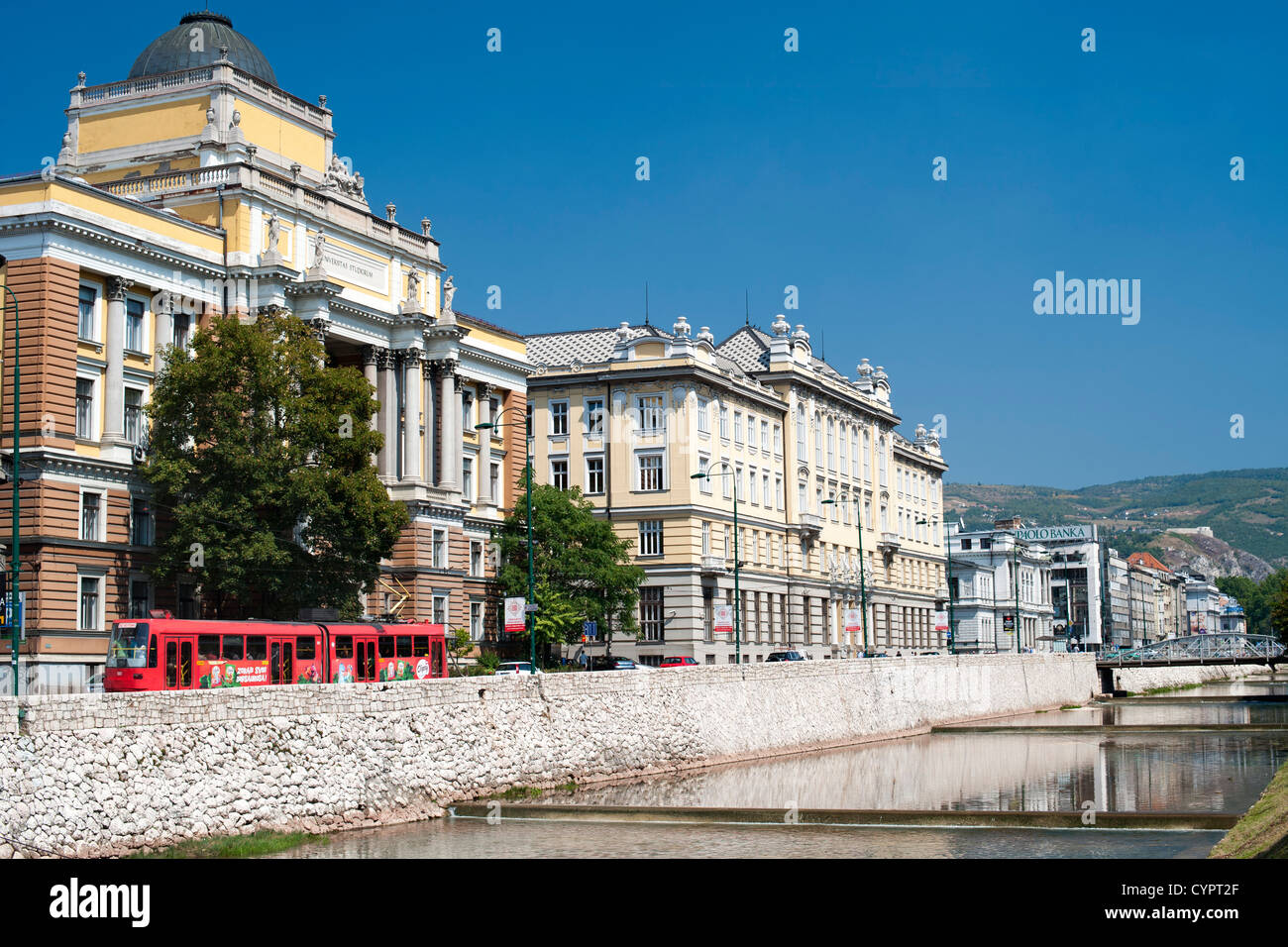 Gebäude entlang Obala Kulina Bana Straße am Nordufer des Flusses Miljacka in Sarajevo, die Hauptstadt von Bosnien und Herzegowina. Stockfoto