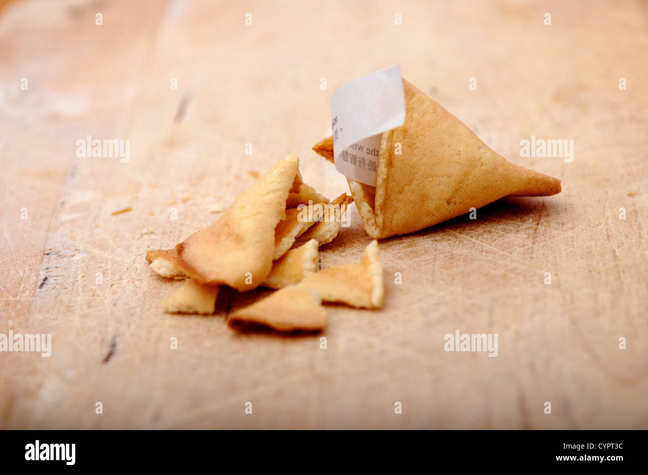 Gebrochenen offenen chinesischen Glückskeks auf ein Schneidbrett aus Holz Stockfoto