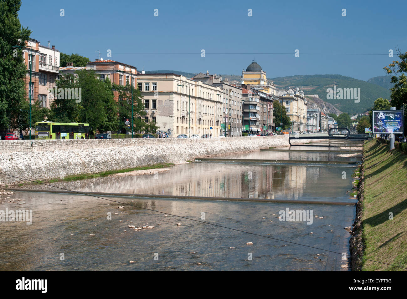 Gebäude entlang Obala Kulina Bana Straße am Nordufer des Flusses Miljacka in Sarajevo, die Hauptstadt von Bosnien und Herzegowina. Stockfoto