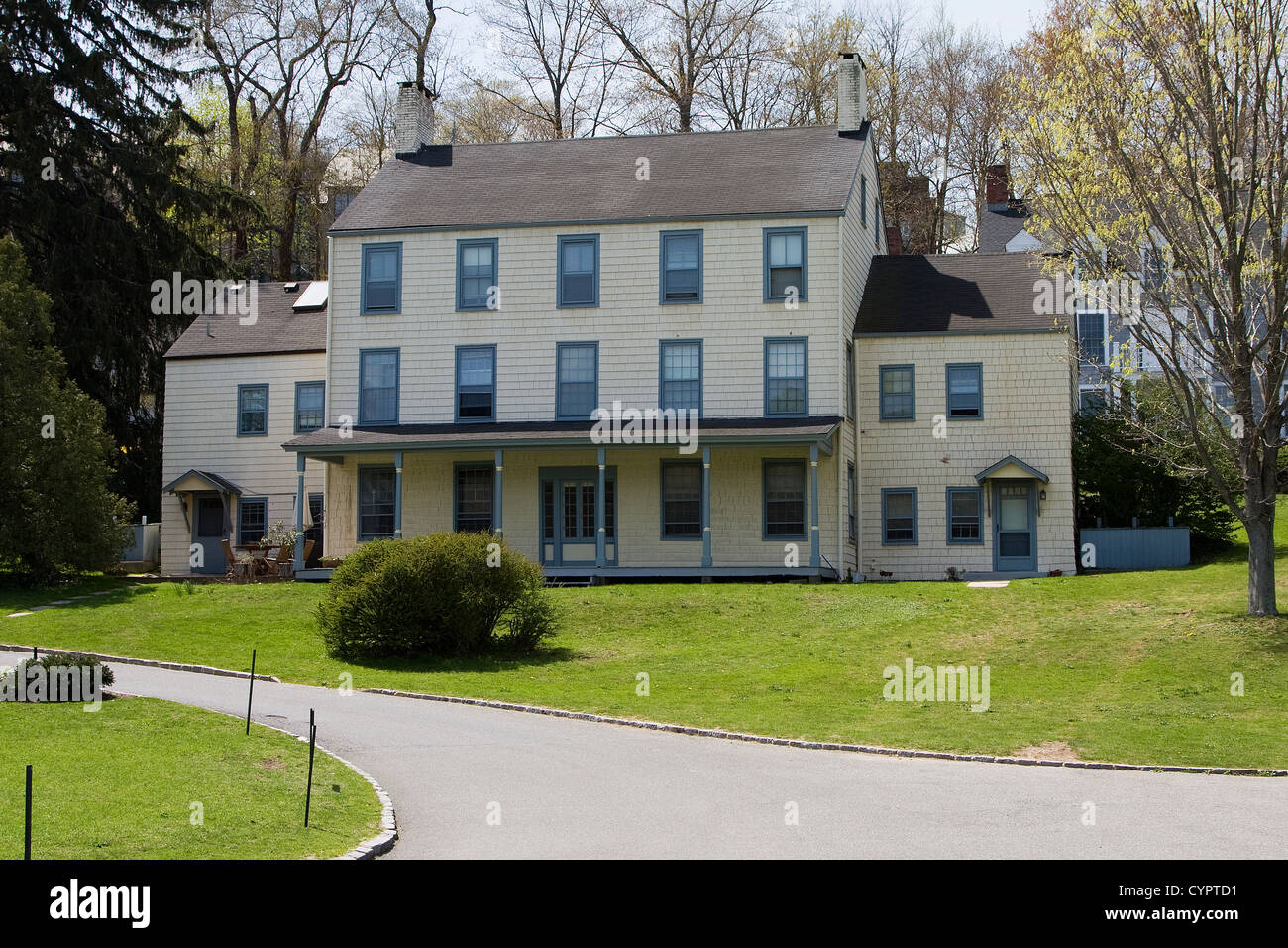 Eine weit entfernte weiße Victorian/Kolonial Villa im Wald an einem Frühlingstag. Stockfoto