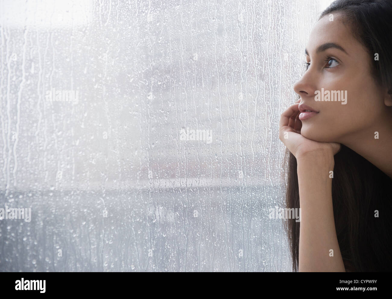 Ernsthafte Hispanic Teenager suchen Fenster Stockfoto