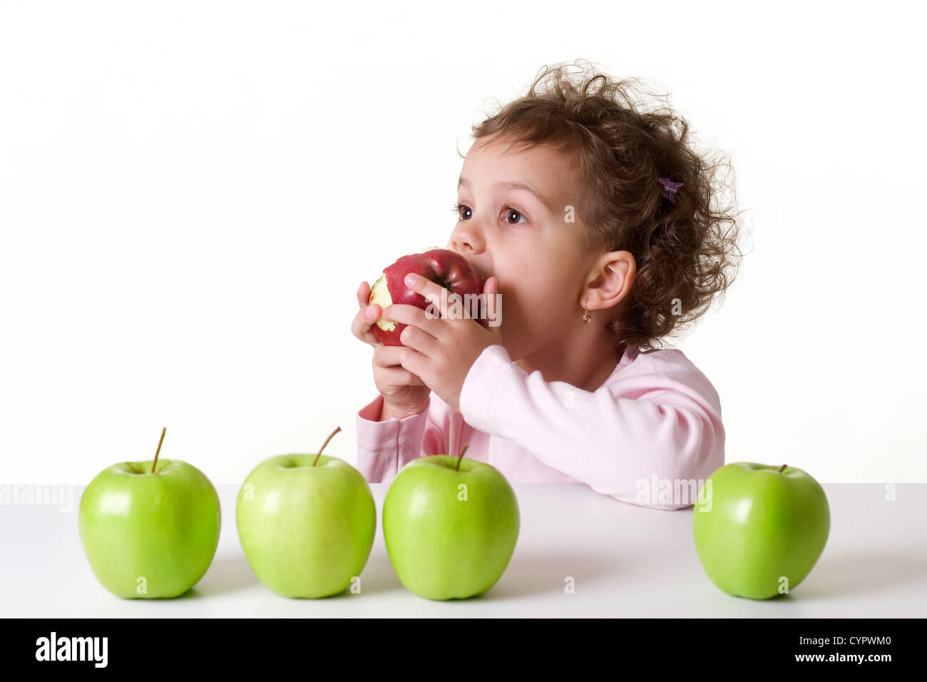 Kaukasische Mädchen, ca. 5-6 Jahre alt, braune Augen, lockiges Haar, Essen einen roten Apfel, isoliert auf weißem Hintergrund Stockfoto