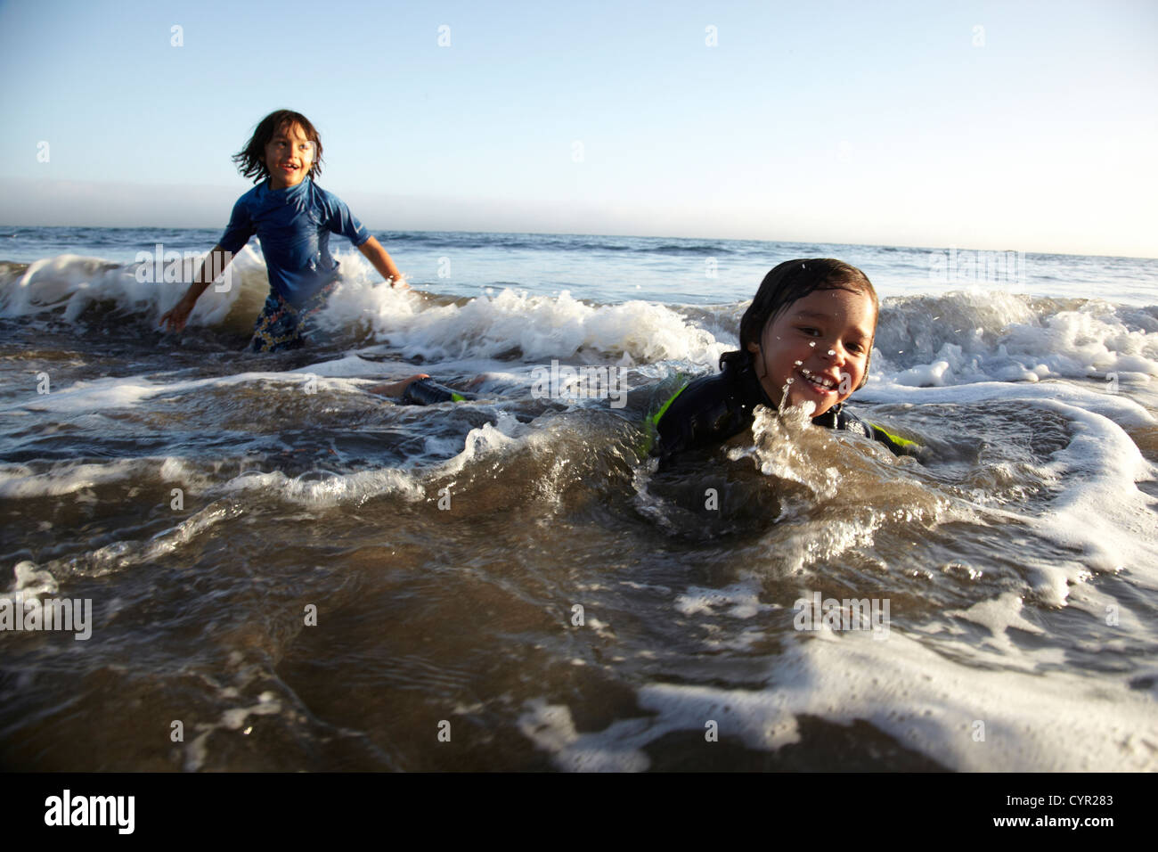 Gemischte Rassen Jungen schwimmen im Ozean Stockfoto