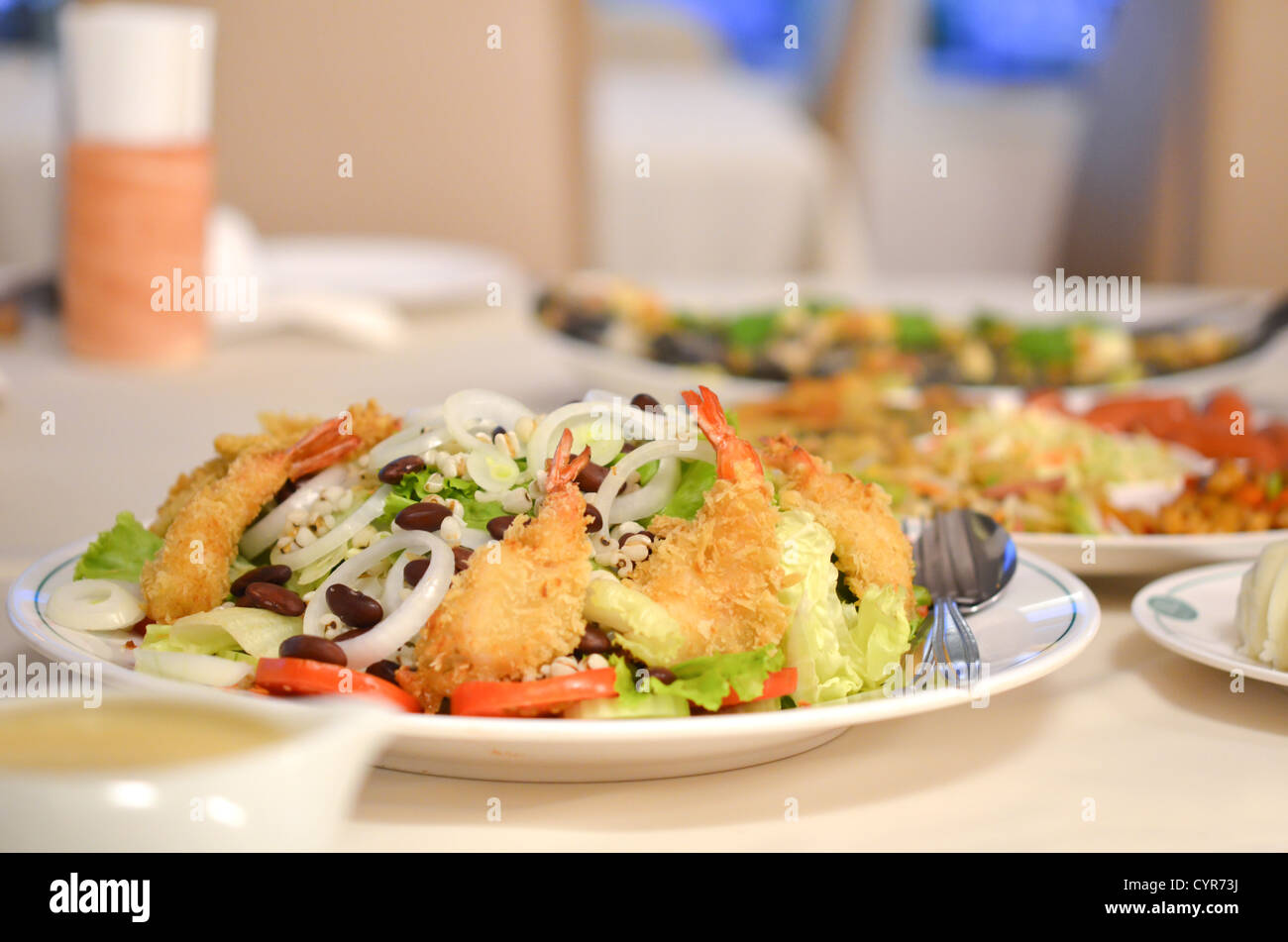 frische Salate und voller Essen am Tisch Stockfoto