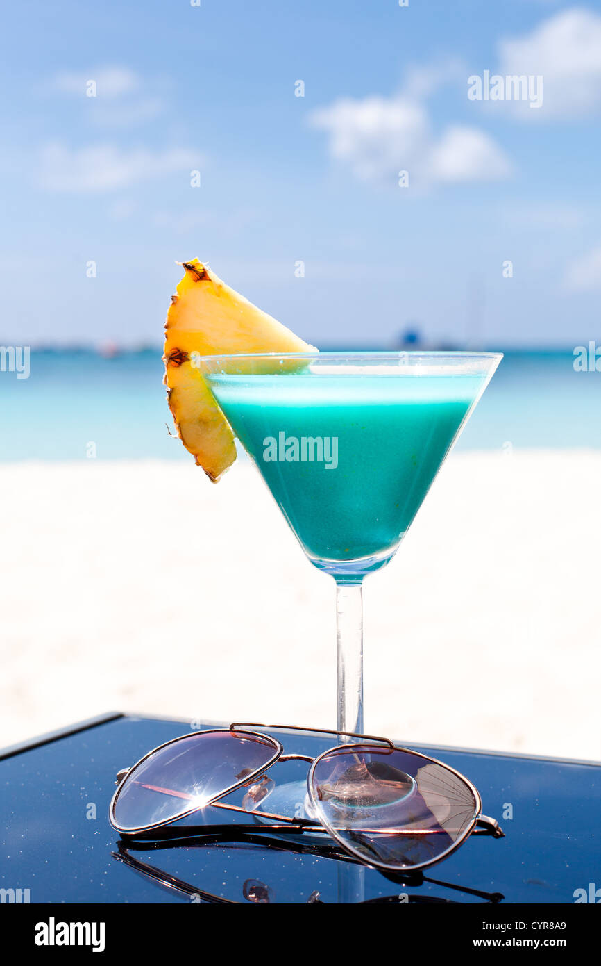 Blue Curacao cocktail mit Scheibe Ananas am weißen Strand Stockfoto