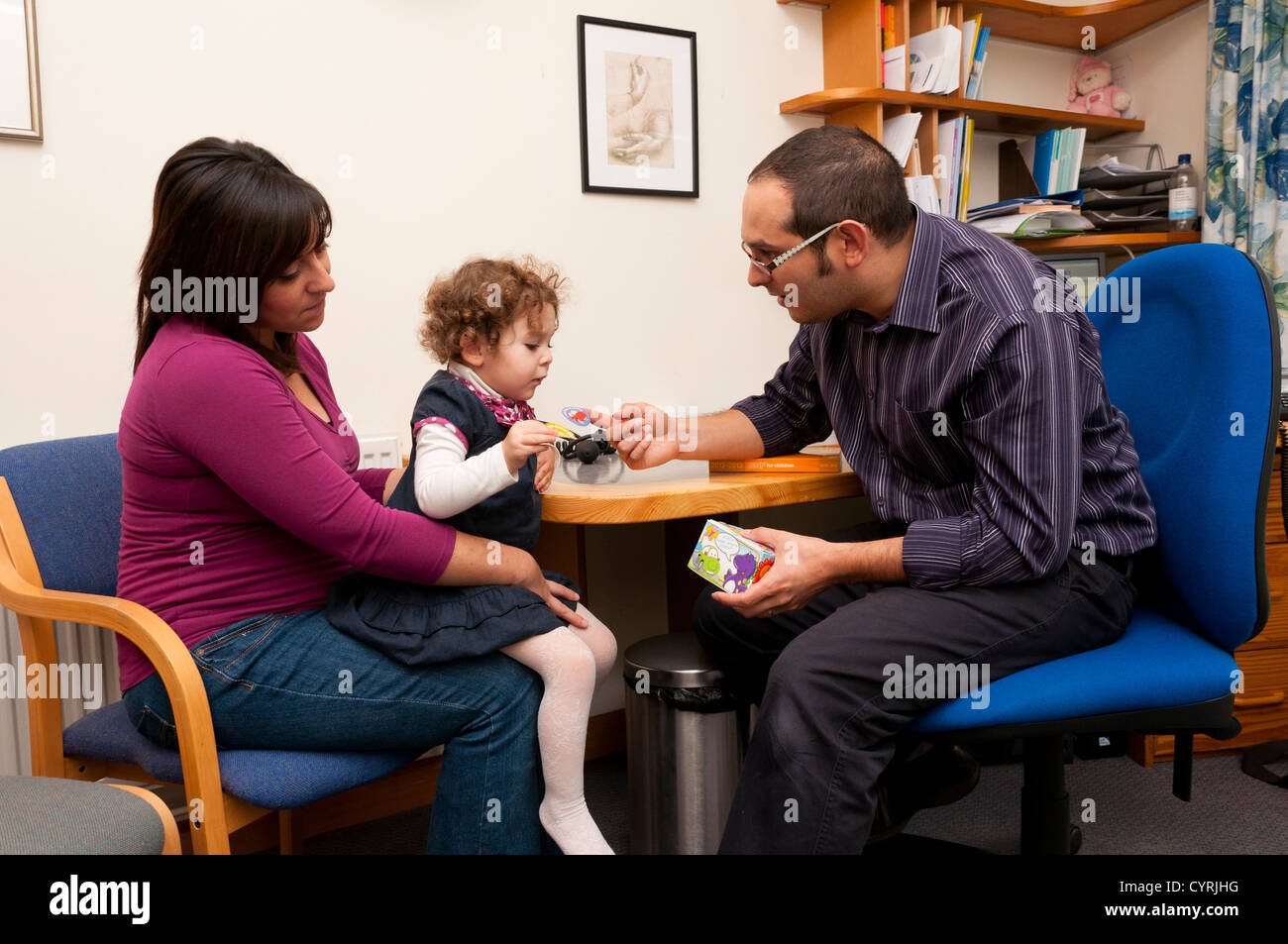 GP-Arzt belohnt Kind Patient mit Aufklebern für sie in einem Beratungsgespräch. Stockfoto