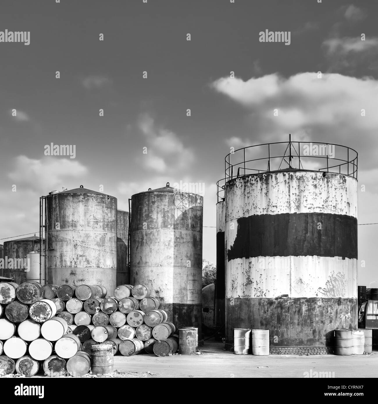 Fabrik-Ansicht mit Turm und Öl Drums im Außenbereich mit schwarzen und weißen Ton. Stockfoto