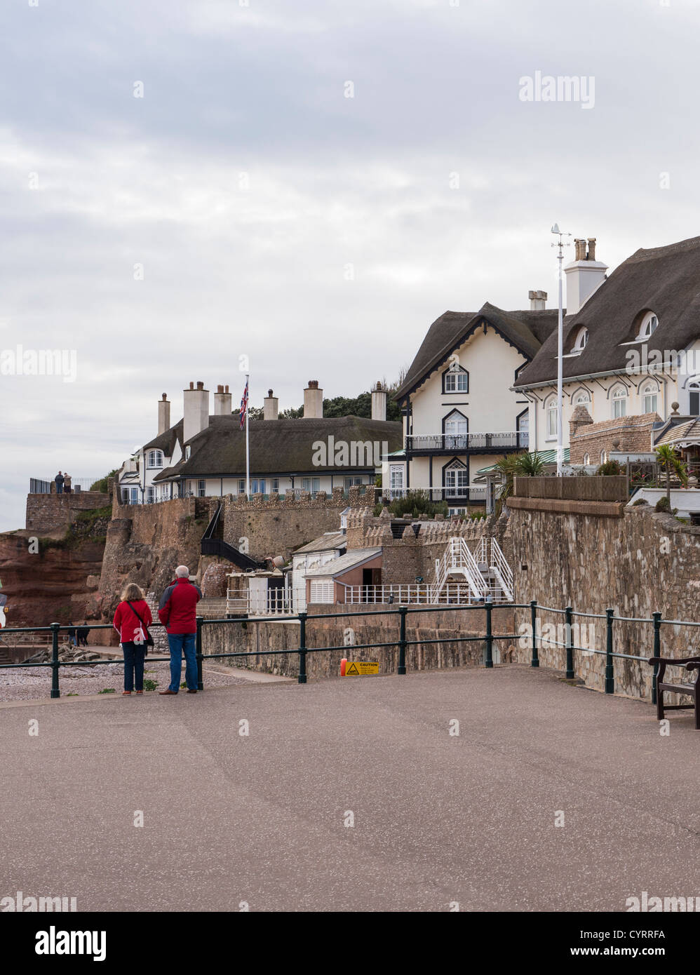 6. November 2012. Sidmouth, Devon, England. Zwei Spaziergänger am Meer entlang mit der Jurassic Coast im Hintergrund. Stockfoto