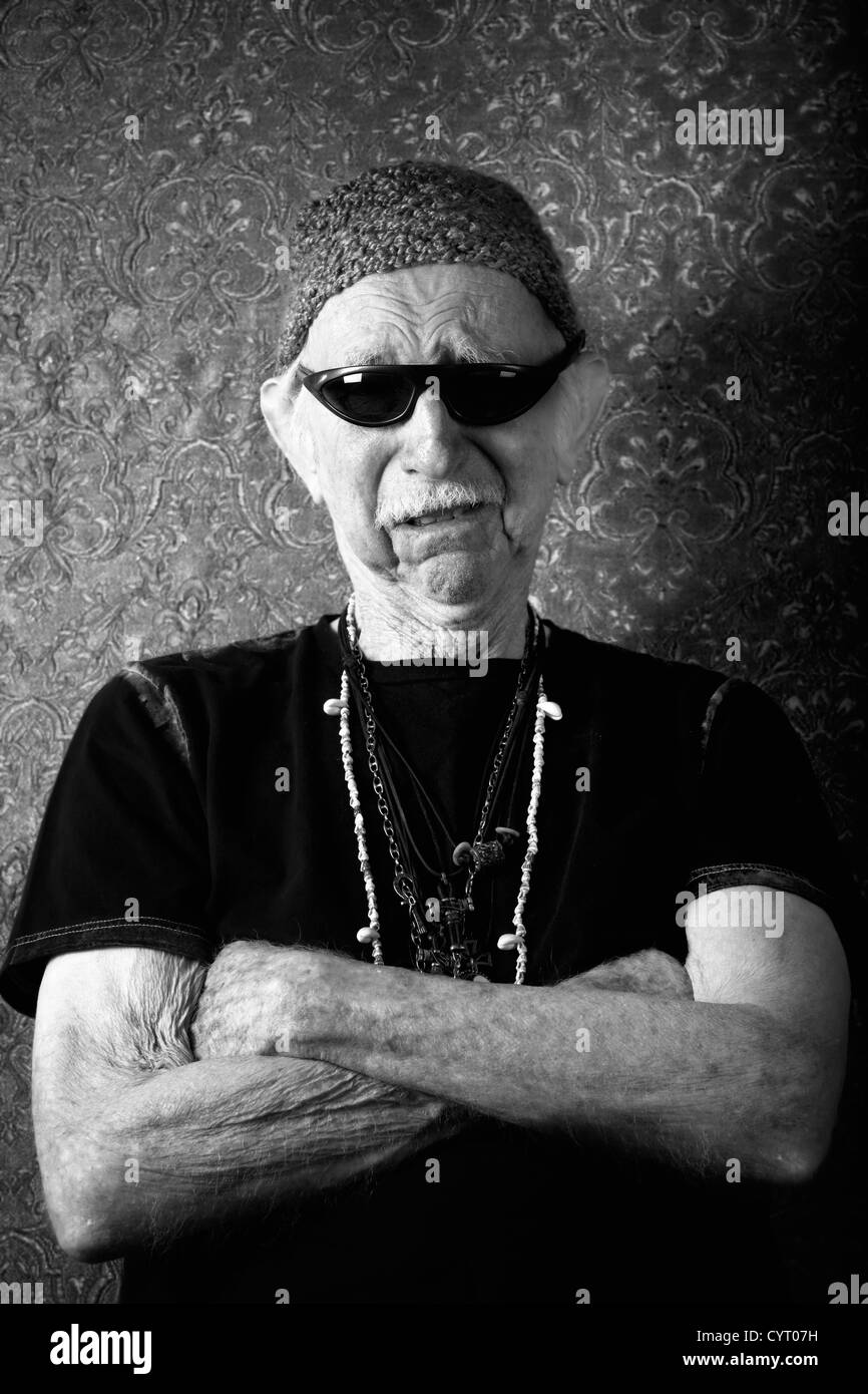 Senior harter Kerl in Strick Mütze an eine Wand gelehnt Stockfoto