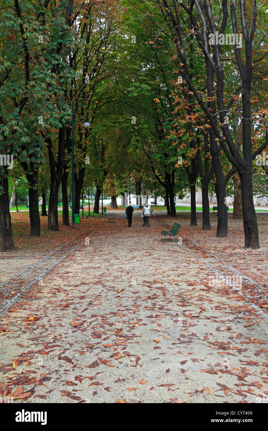 Zwei Passanten einen Baum gesäumten Pfad durch Parco Sempione in Herbst, Mailand, Italien, Europa. Stockfoto