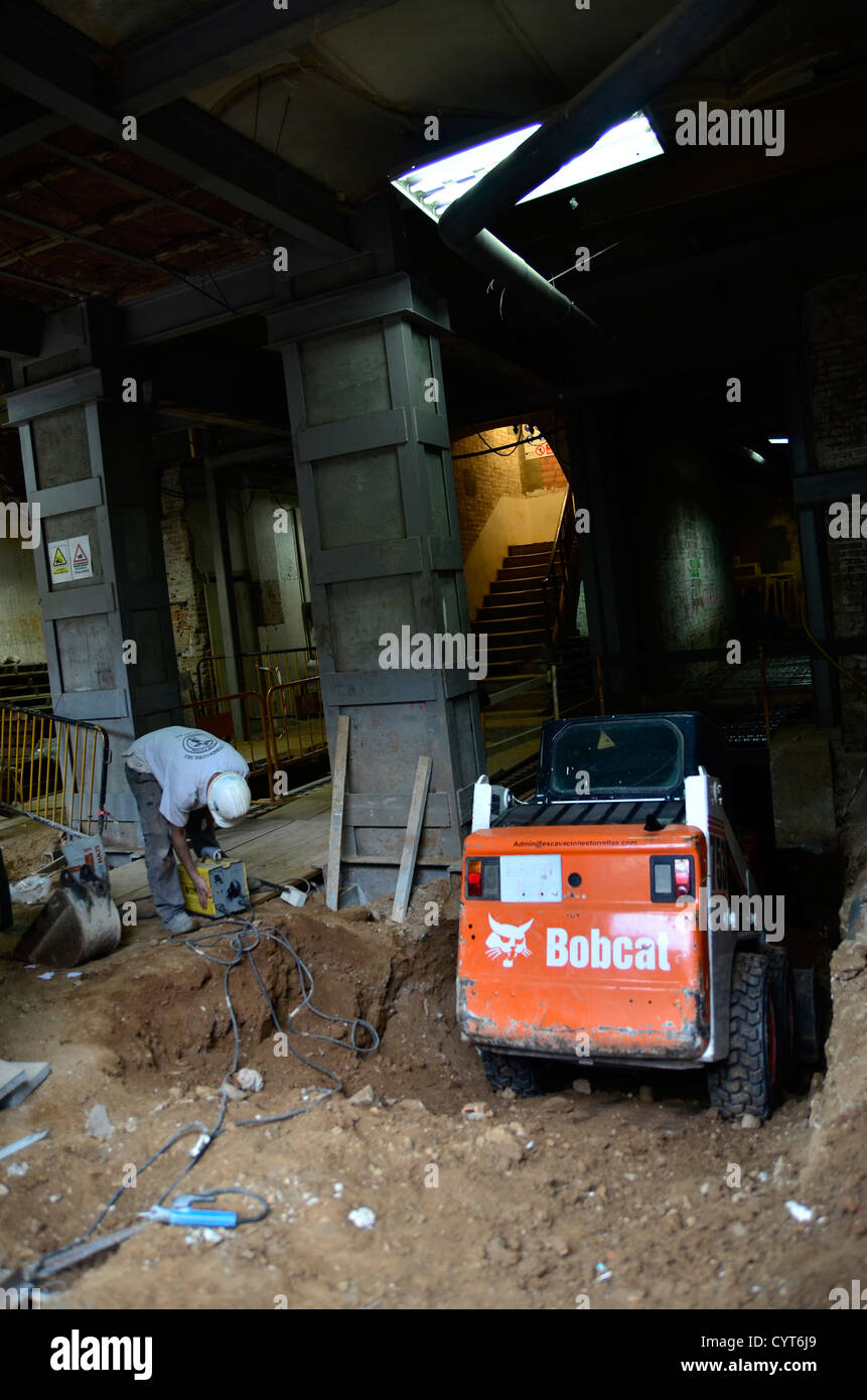 Arbeiten innerhalb eines Gebäudes mit einem Bobcat Bagger Stockfoto