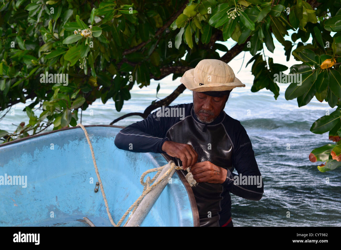 Mikronesien alte Mann fesselt sein Boot zu einem Baum, Na Insel, Madolenihmw Provinz, Pohnpei, Föderierte Staaten von Mikronesien Stockfoto
