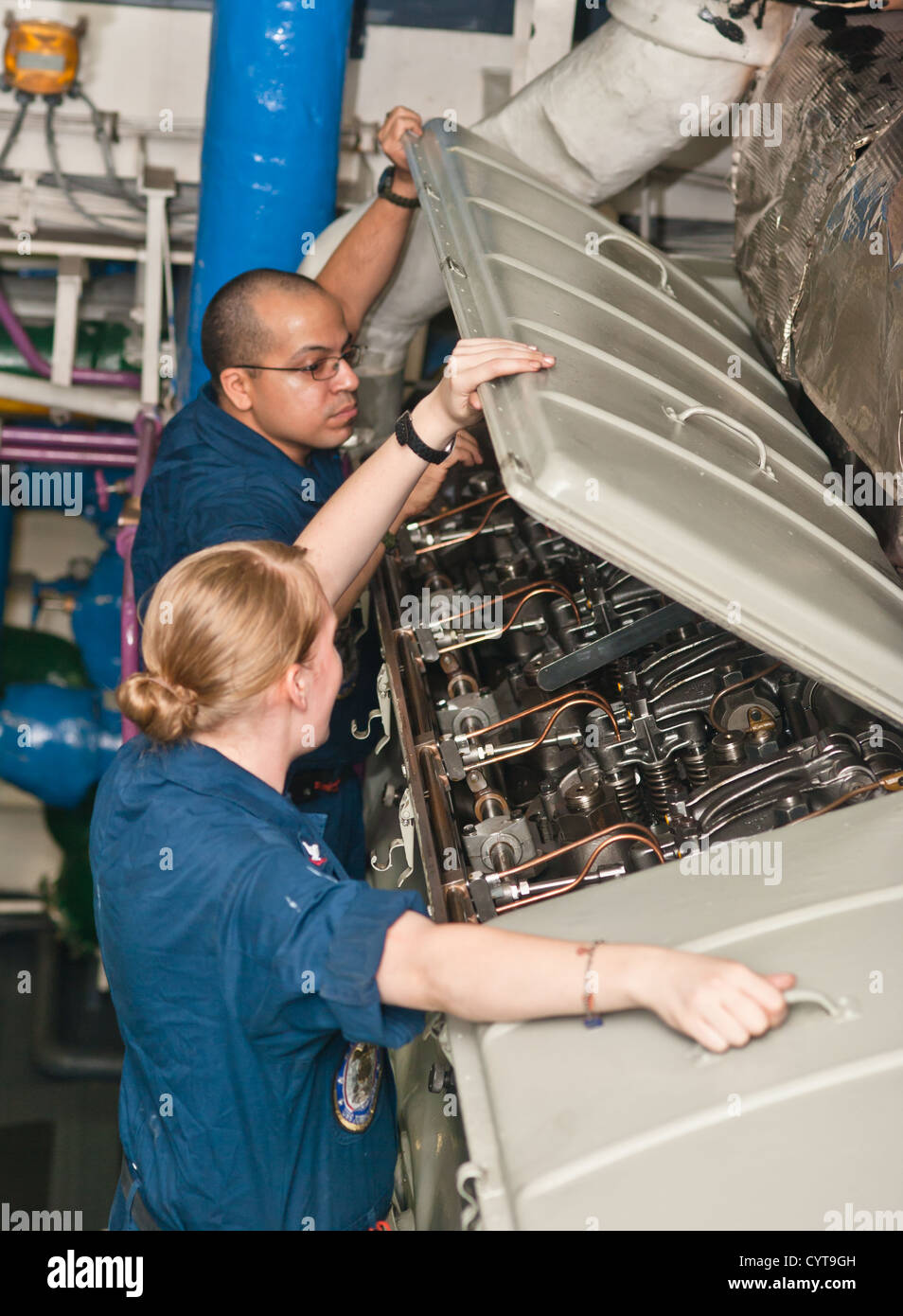 Matrosen heben die Motorabdeckung auf die Nummer zwei Diesel-Notstrom-Generator an Bord des Flugzeugträgers USS John C. Stennis (CVN-74). John C. Stennis ist in den USA bereitgestellt 5. Flotte Aufgabengebiet Durchführung von maritimen Sicherheits-Operationen, th Stockfoto