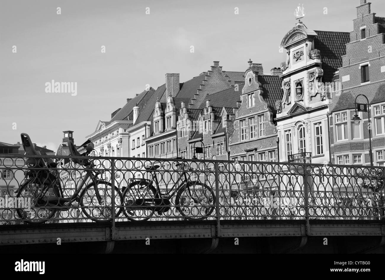 Gent - Fahrrad über die Brücke und die typischen Backstein beherbergt im Morgenlicht Stockfoto