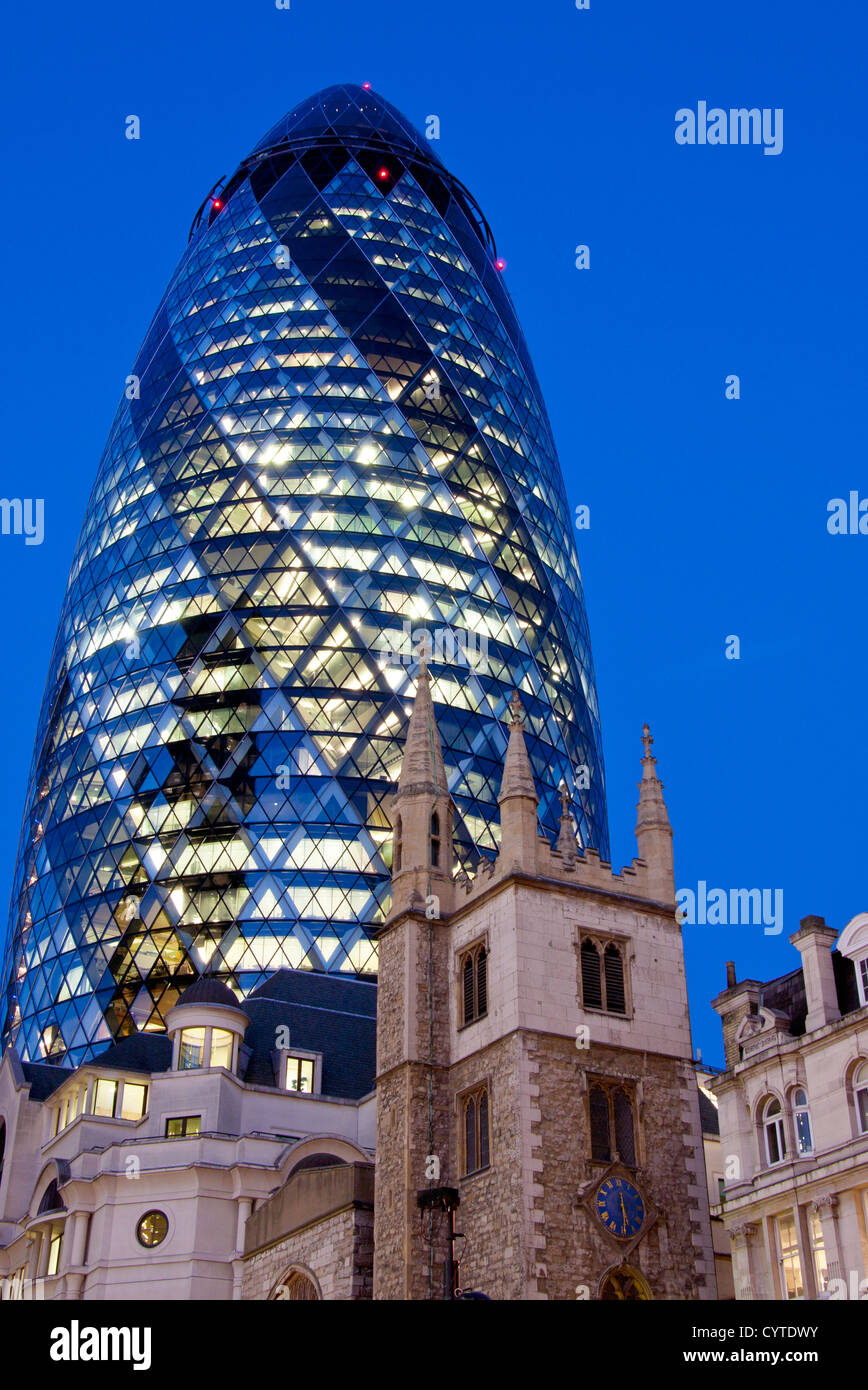 Swiss Re Gebäude 30 St Mary Axe auch bekannt als die Gurke in der Nacht mit Turm von St. Andrew Undershaft Stadt von London England UK Stockfoto