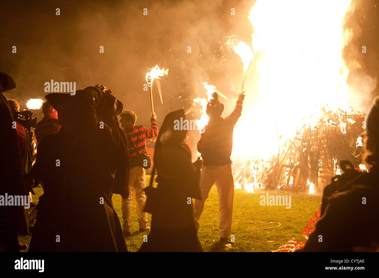 Mitglieder der Lewes Southover Lagerfeuer Gesellschaft werfen ihre Fackeln auf dem Lagerfeuer im Rahmen des 5. November feiern Stockfoto