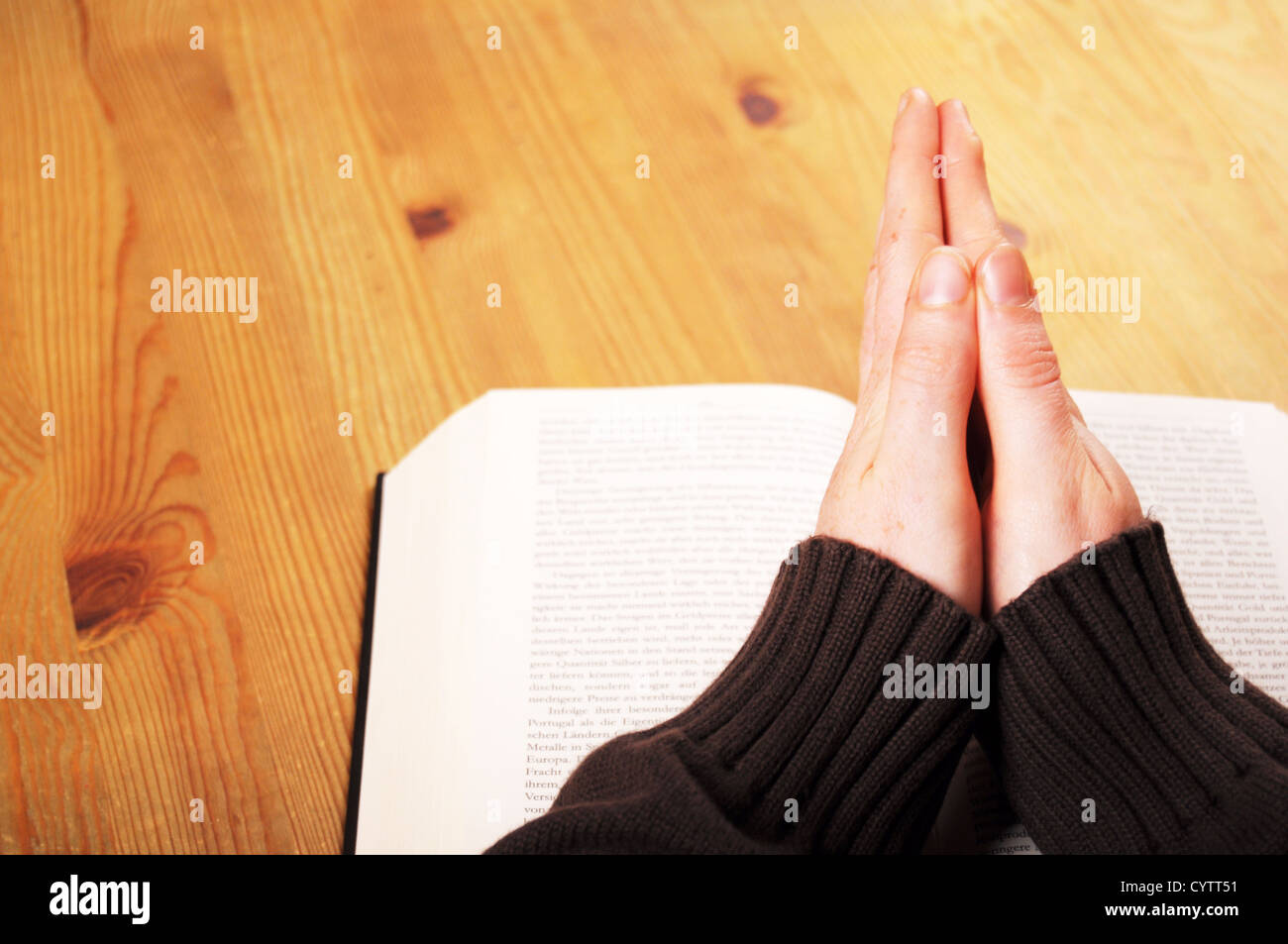 Betende Hände und Buch mit christlichen Religion Konzept Stockfoto