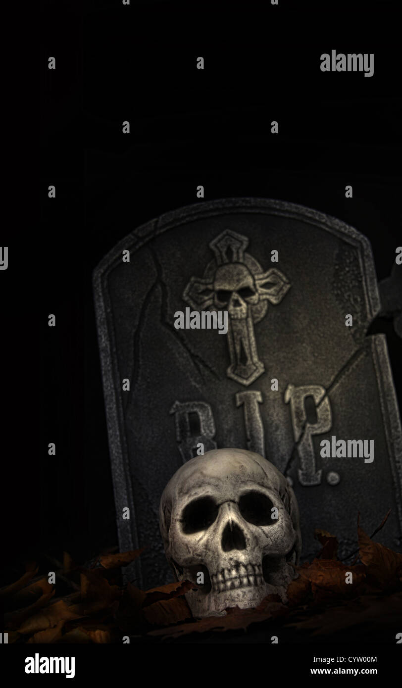 Gruselige Grabstein mit Totenkopf auf schwarzem Hintergrund Stockfoto