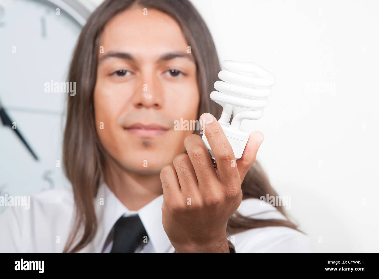 Hübscher junger Mann hält Energie effiziente Glühbirne Stockfoto