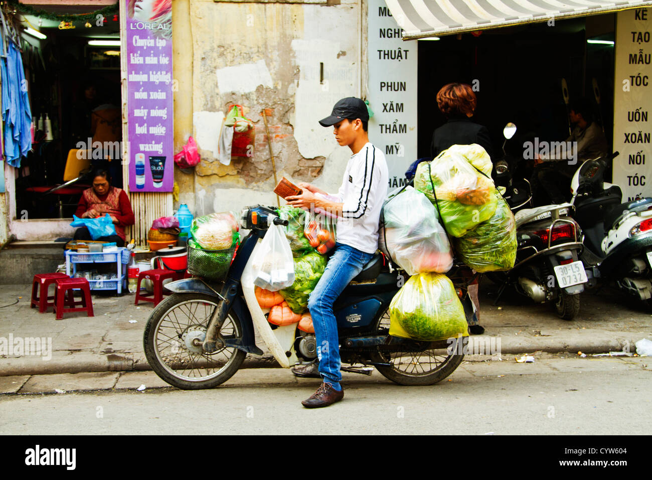 Bote auf Motorrad beladen mit Gemüse, Hanoi, Vietnam. Stockfoto