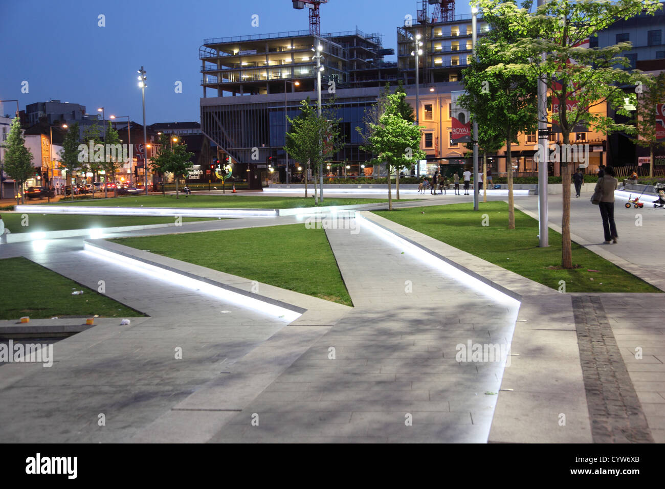 General Gordon Ort, Woolwich, UK. Einen modernen, gepflegten Stadtplatz in der Abenddämmerung mit breiten Bürgersteigen, Wasser Feature und grass Bereiche. Stockfoto