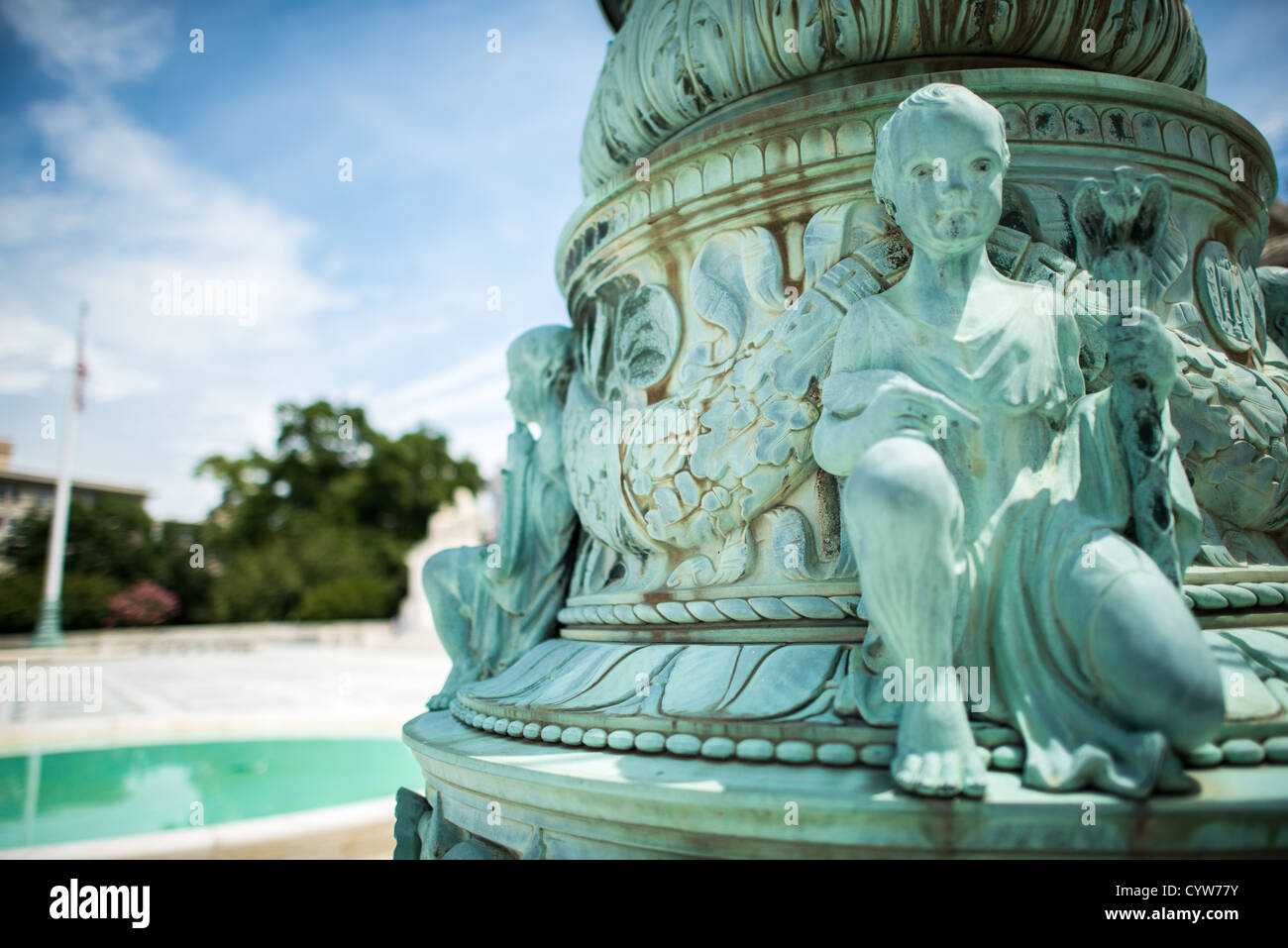 WASHINGTON, D.C. — die kunstvoll verzierten Fahnenmasten aus Bronze und Marmor am U.S. Supreme Court Building, entworfen von dem Bildhauer John James Donnelly Jr. und fertiggestellt 1938, zeigen raffinierte neoklassizistische Details über ihre neunstufige, an Hochzeitstorten erinnernde Struktur. Jede achteckige Basis hat ein Relief von Vorhängen, gefolgt von aufsteigenden Ebenen mit Schilden, Rinceaux, Dornen, Muscheln, Delfinen, Cherubs mit Gerechtigkeitssymbolen, Akanthusblättern, Schnecken und Anthemion-Designs. Diese Basen sind 9 Fuß hoch und 6 Fuß breit und stützen geriffelte Säulen mit Adlerfinialen. Die Fahnenmasten e Stockfoto