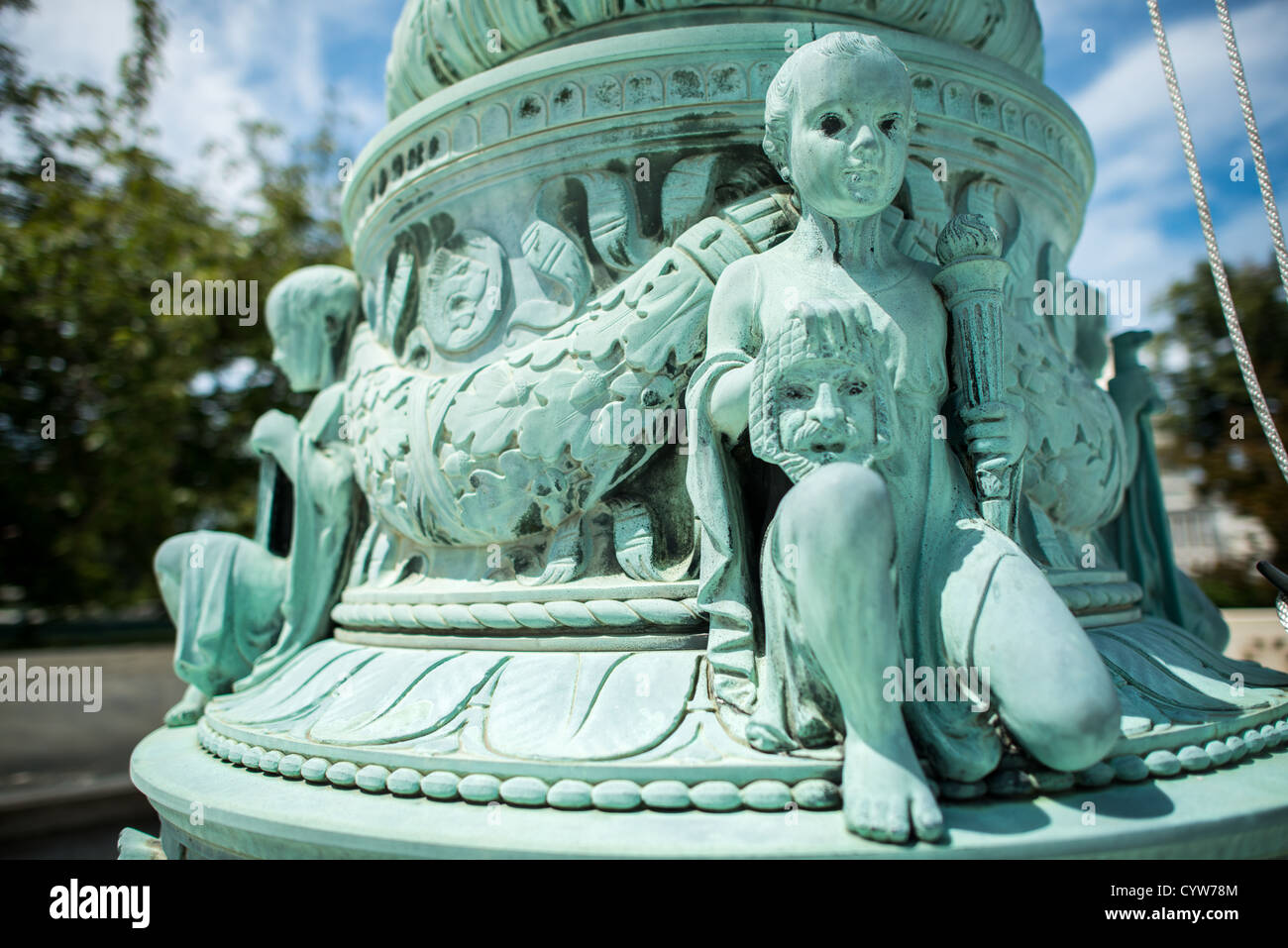 WASHINGTON, D.C. — die kunstvoll verzierten Fahnenmasten aus Bronze und Marmor am U.S. Supreme Court Building, entworfen von dem Bildhauer John James Donnelly Jr. und fertiggestellt 1938, zeigen raffinierte neoklassizistische Details über ihre neunstufige, an Hochzeitstorten erinnernde Struktur. Jede achteckige Basis hat ein Relief von Vorhängen, gefolgt von aufsteigenden Ebenen mit Schilden, Rinceaux, Dornen, Muscheln, Delfinen, Cherubs mit Gerechtigkeitssymbolen, Akanthusblättern, Schnecken und Anthemion-Designs. Diese Basen sind 9 Fuß hoch und 6 Fuß breit und stützen geriffelte Säulen mit Adlerfinialen. Die Fahnenmasten e Stockfoto